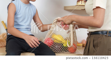 Unpacking groceries in a reusable mesh bag Unpacking groceries in a reusable mesh bag 138110423
