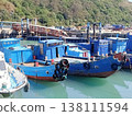 Traditional blue wooden fishing boats moored in a calm harbor 138111594