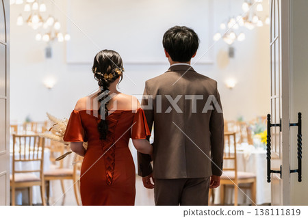 The bride and groom open the doors to the reception hall at their wedding. The bride and groom open the doors to the reception hall at their wedding. 138111819