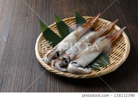 Squid served in a basket against a wood grain background. Squid served in a basket against a wood grain background. 138112390
