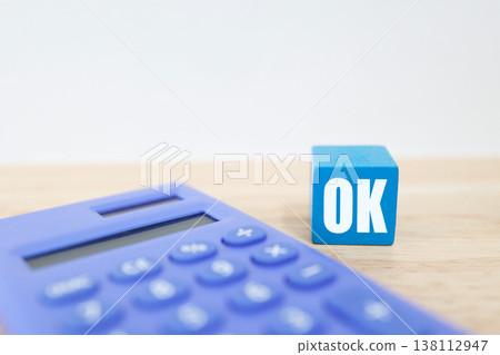 A household or business image using a calculator and OK blocks to indicate approval. A household or business image using a calculator and OK blocks to indicate approval. 138112947
