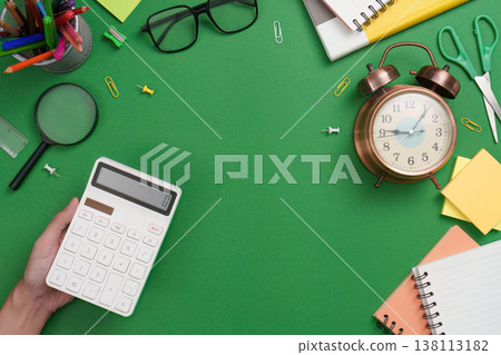 Calculator and school supplies on green desk Calculator and school supplies on green desk 138113182