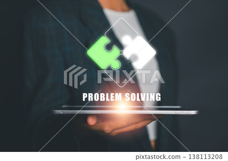Businessperson holding tablet with puzzle pieces, symbolizing problem solving and innovation in technology. Businessperson holding tablet with puzzle pieces, symbolizing problem solving and innovation in technology. 138113208