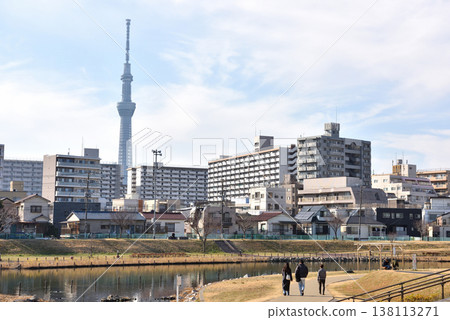 The Tokyo Skytree as seen from the Old Nakagawa River, and people strolling along the riverbank. The Tokyo Skytree as seen from the Old Nakagawa River, and people strolling along the riverbank. 138113271