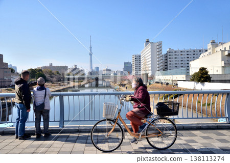人們從橫跨舊中川河的福來橋上眺望東京晴空塔。 人們從橫跨舊中川河的福來橋上眺望東京晴空塔。 138113274