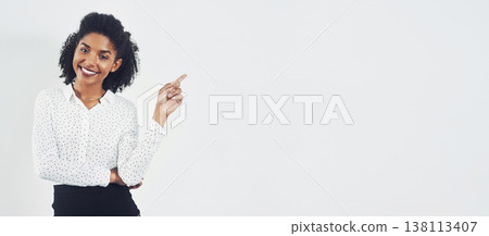 Pointing, banner and portrait of businesswoman in studio with mockup space for marketing or advertising. Happy, smile and professional female person with show gesture for mock up by white background. 138113407