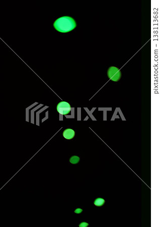Green light, bokeh and shine on dark background isolated on a mockup space. Blur, black backdrop and defocused glow, sparkle or glitter at night for Christmas, holiday or party with magic color dots 138113682