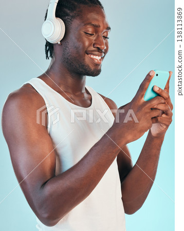 Smartphone, headphones and black man listening to music, smile with audio streaming and chat isolated on blue background. Happiness, sound and mobile app, podcast or radio with connectivity in studio Smartphone, headphones and black man listening to music, smile with audio streaming and chat isolated on blue background. Happiness, sound and mobile app, podcast or radio with connectivity in studio 138113869