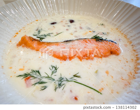 Clam chowder. A white stew containing clams and salmon fillets. 138114302