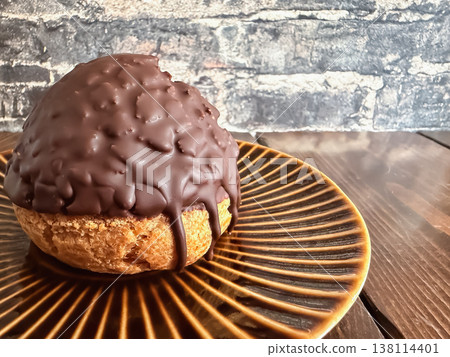 一種外形類似閃電泡芙的奶油泡芙，外層裹著巧克力。 138114401