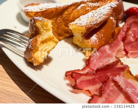 French toast and crispy bacon. Cross-section of the French toast. French toast and crispy bacon. Cross-section of the French toast. 138114425