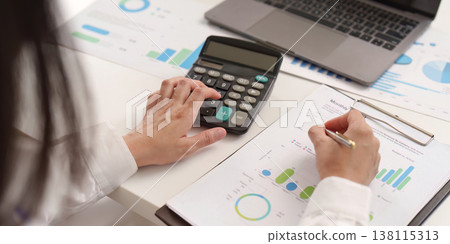 Accountant calculating data with charts and graphs 138115313