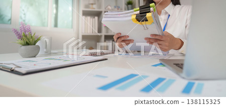 Accountant organizing financial reports in an office Accountant organizing financial reports in an office 138115325