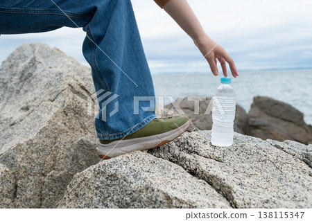 拿著塑膠瓶水的人 138115347