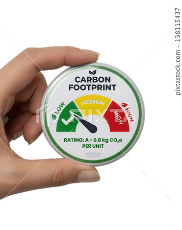 Hand holding a carbon footprint rating badge with an eco-score, representing sustainability, environmental impact, and green certification 138115437