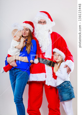 Mother, Santa and two daughters christmas family photo 138115448