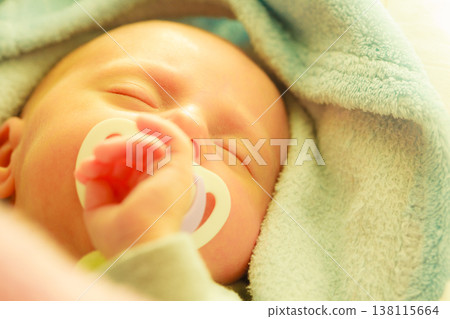 Closeup of little newborn sleeping with teat in mouth Closeup of little newborn sleeping with teat in mouth 138115664