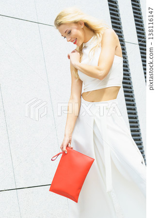 Fashion woman white outfit with red handbag 138116147