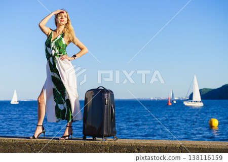 woman with suitcase against yachts on sea 138116159