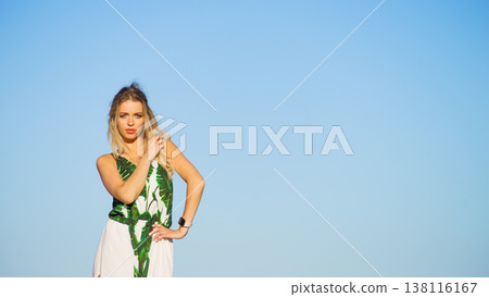 Woman in summer long dress against blue sky 138116167