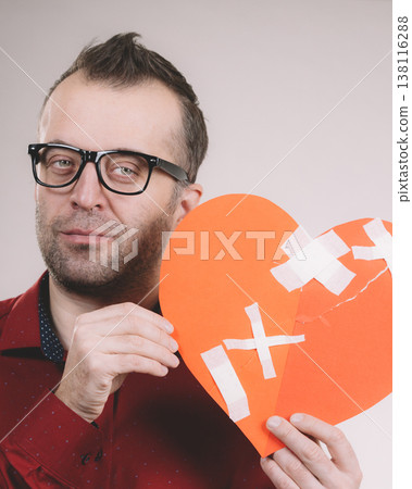 Sad adult man holding broken heart 138116288