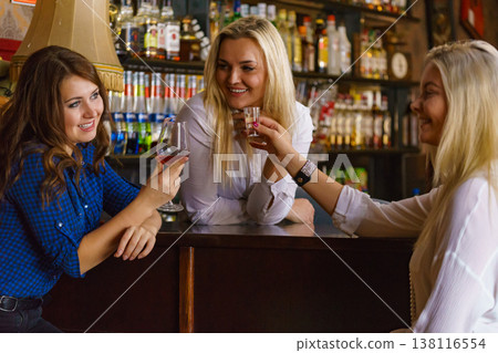 Girls in pub club gossiping and talking Girls in pub club gossiping and talking 138116554