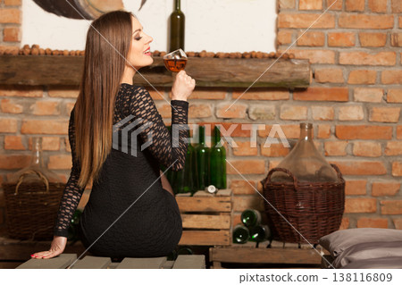 Woman tasting wine in rural cottage interior 138116809