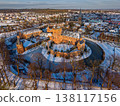 Aerial view of the medieval Huis Bergh Castle in s-Heerenberg, Netherlands. A stunning winter scene with a snow covered fortress, frozen moat, and a charming European town during golden hour. 138117156