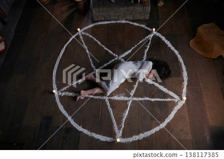 Battered female figure surrounded by candles after spiritual ritual Battered female figure surrounded by candles after spiritual ritual 138117385