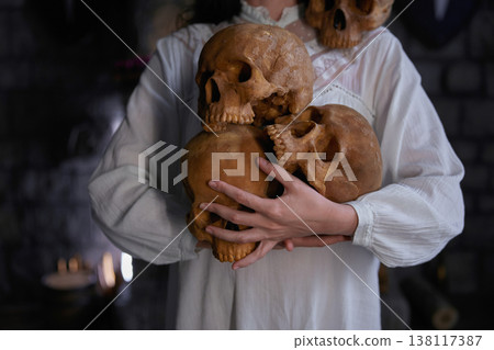 Serene figure in white gently cradles ancient ancestral memories amid eerie atmospheric lighting Serene figure in white gently cradles ancient ancestral memories amid eerie atmospheric lighting 138117387