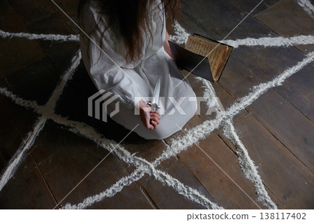 Woman immersed in ritualistic symbols within mysterious setting Woman immersed in ritualistic symbols within mysterious setting 138117402