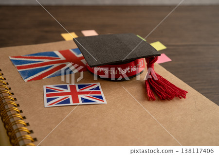 UK flag with graduate hat on english language book. UK flag with graduate hat on english language book. 138117406