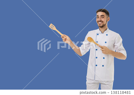 Occupation, Man in chef outfit shows cooking tools and smiles Occupation, Man in chef outfit shows cooking tools and smiles 138118481