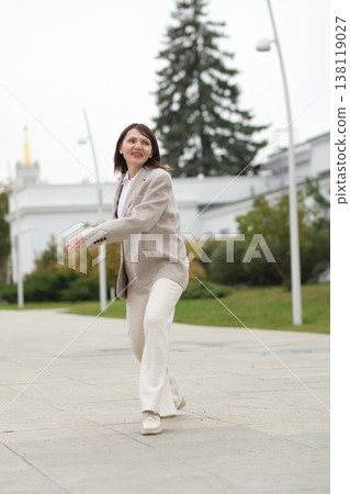 A mature woman spins around outdoors, her expression full of joy and vitality. It reflects modern aging ideals confidence, movement, and emotional resilience at any stage of life. 138119027