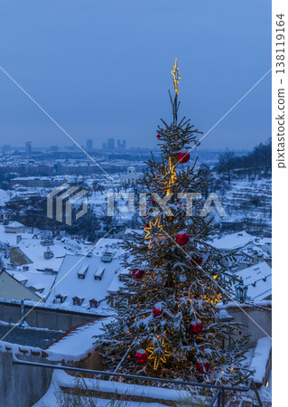 Christmas tree glowing in snowy Prague cityscape 138119164