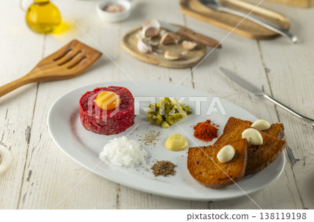 Steak tartare dish with egg yolk and ingredients 138119198