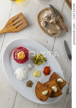 Steak tartare dish serving raw beef and ingredients Steak tartare dish serving raw beef and ingredients 138119199