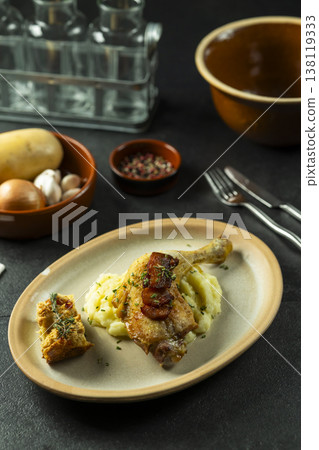Roasted duck leg confit with mashed potatoes and herbs Roasted duck leg confit with mashed potatoes and herbs 138119333