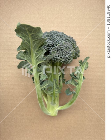 Overhead view of fresh broccoli with leaves, against a kraft paper background. Overhead view of fresh broccoli with leaves, against a kraft paper background. 138119940