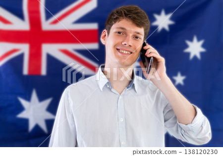 Young guy talking on phone in front of Australian flag 138120230