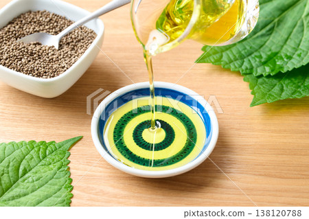 Pour perilla oil into a small dish. Pour perilla oil into a small dish. 138120788