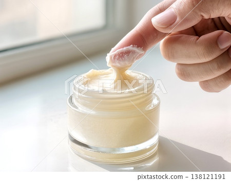 Finger Dipping into Glass Jar of Thick Moisturizing Face Cream Finger Dipping into Glass Jar of Thick Moisturizing Face Cream 138121191