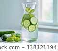 Refreshing detox water with cucumber slices and fresh mint in a glass carafe on a bright morning background. 138121194