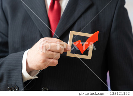Vote with your heart. A man in a business suit holds a voting check mark over his heart. Elections and referendums. Civic engagement and personal values influence democratic decision making 138121332