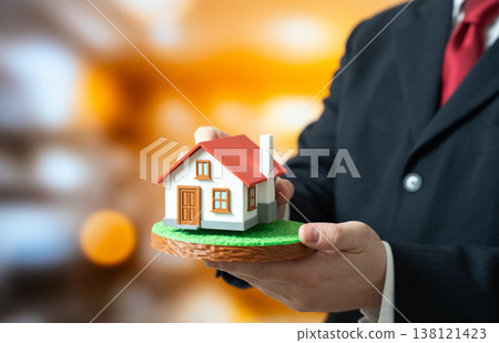 A man lays a house on a plot of land. Housing design and construction. Property development planning ensures efficient building. Investment supports residential growth and urban expansion. A man lays a house on a plot of land. Housing design and construction. Property development planning ensures efficient building. Investment supports residential growth and urban expansion. 138121423