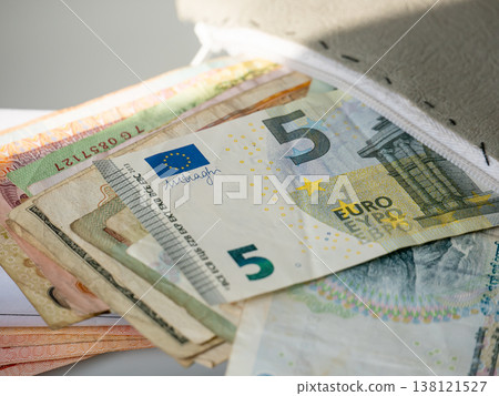 Five Euro banknote inside leather wallet. Close up of paper currency in purse. Financial savings, cash management, personal budget and banking concept. Wealth and payment method. Five Euro banknote inside leather wallet. Close up of paper currency in purse. Financial savings, cash management, personal budget and banking concept. Wealth and payment method. 138121527