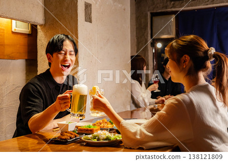 Men and women eating at an izakaya Men and women eating at an izakaya 138121809