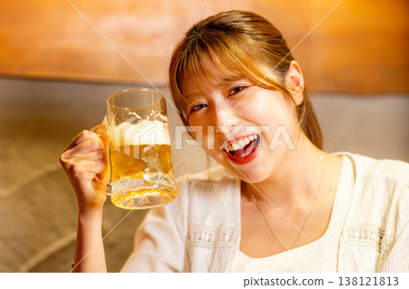 A woman drinking beer with a smile 138121813