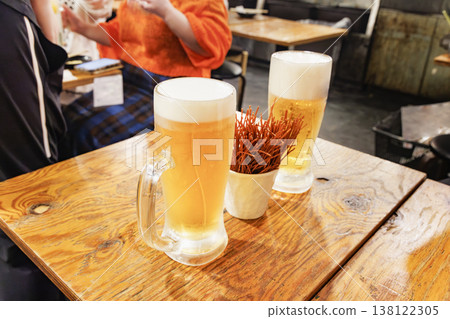 A mug of beer and snacks placed on the table in the izakaya. A mug of beer and snacks placed on the table in the izakaya. 138122305