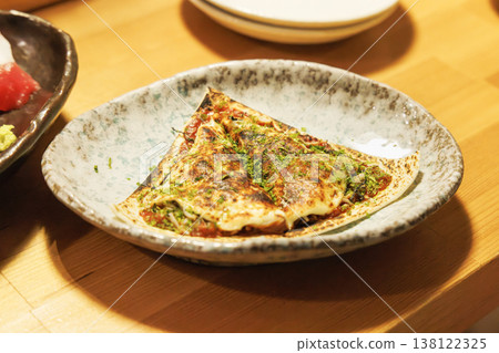 A thin-crust pizza with melted cheese that has been baked to a golden brown. 138122325